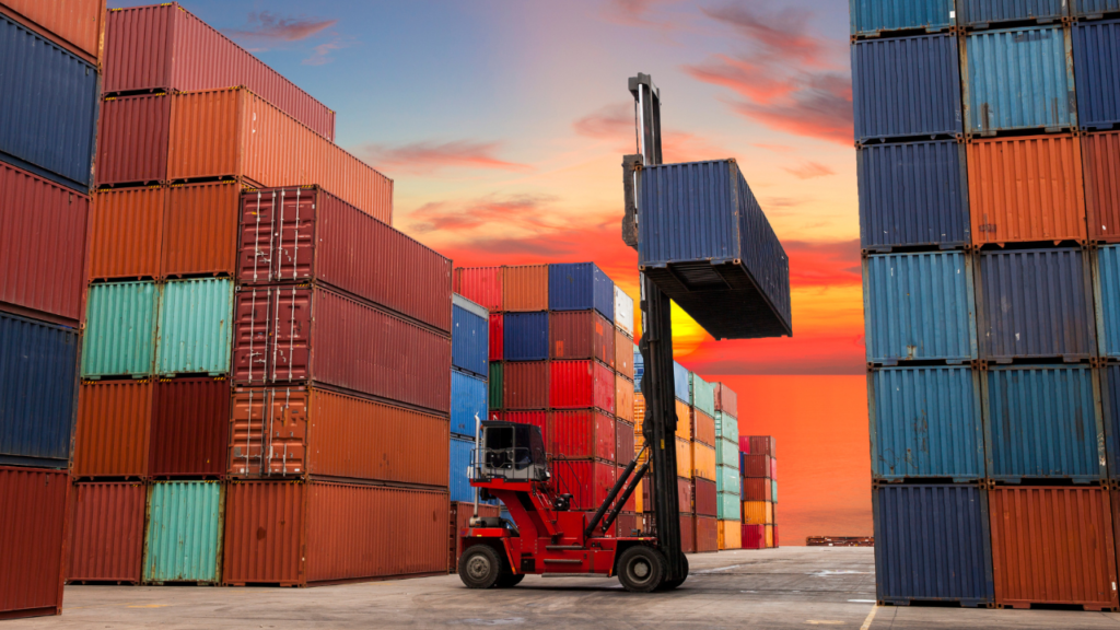 Boender-containers worden gestapeld en verplaatst met een heftruck in een haven bij zonsondergang